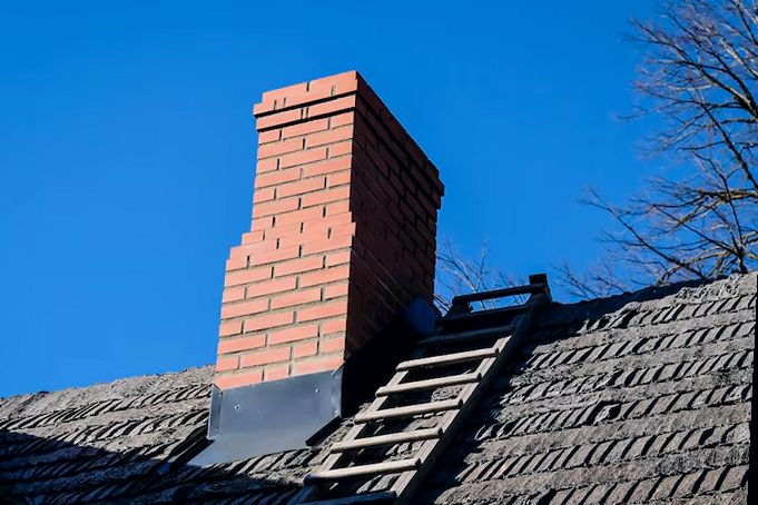 Freshly rebuilt brick chimney above a Brooklyn roofline